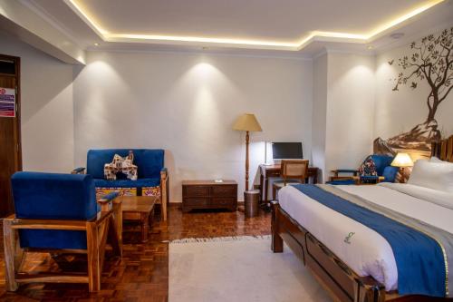 a bedroom with a bed and two chairs and a desk at Gigiri Lion Villas I in Nairobi
