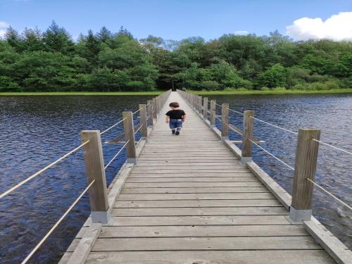 a boy walking across a bridge over a body of water at Modern holiday home in Crux-La-Ville with terrace in Crux-la-Ville