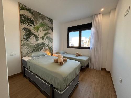 a bedroom with two beds and a large window at Casa Mia in Torrevieja