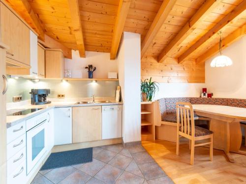 a kitchen with white cabinets and a table in a room at Welcoming apartment in Stummerberg with terrace in Stummerberg