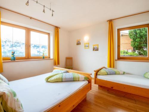 two beds in a room with two windows at Welcoming apartment in Stummerberg with terrace in Stummerberg