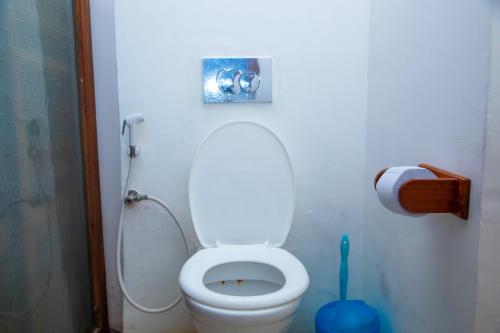a bathroom with a toilet with a toilet brush at Art Hotel Zanzibar in Jambiani