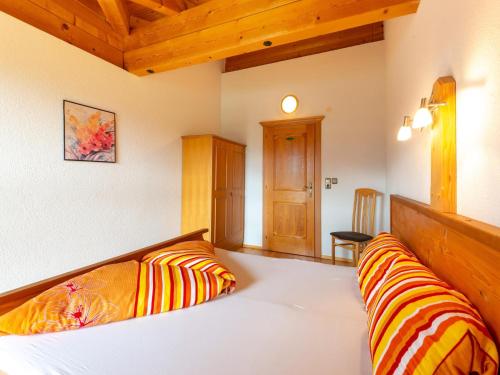 a bedroom with two beds with orange and yellow striped pillows at Welcoming apartment in Stummerberg with terrace in Stummerberg