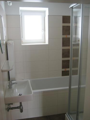 baño con ducha, lavabo y ventana en Gästehaus Santer, en Rothenthurn