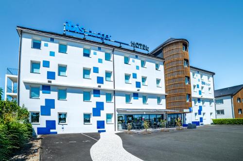 a white building with blue squares on it at ibis budget La Roche Sur Yon Vendespace in Mouilleron-le-Captif