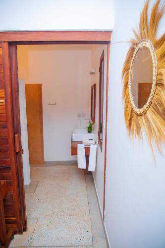 a hallway with a mirror and a bathroom at Art Hotel Zanzibar in Jambiani