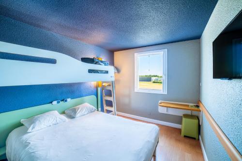 a bedroom with a bunk bed and a window at ibis budget La Roche Sur Yon Vendespace in Mouilleron-le-Captif