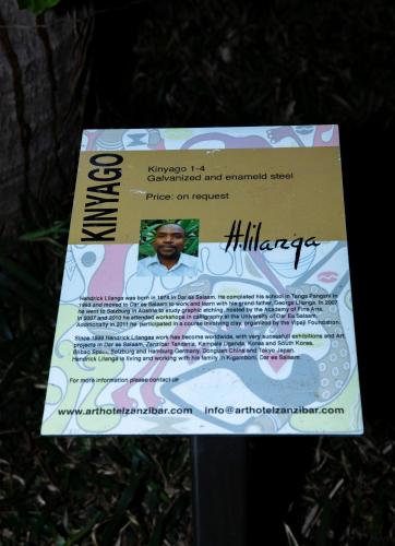a sign that is sitting in the grass at Art Hotel Zanzibar in Jambiani