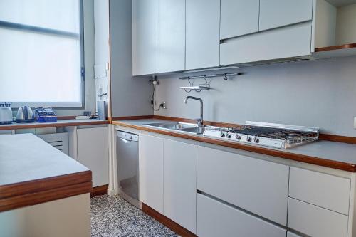 a kitchen with white cabinets and a sink at Milan Retreats in Milan