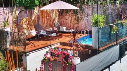 a patio with a pool and chairs and an umbrella at Mansarda con vista lago in Sulzano