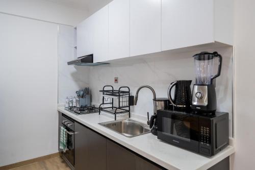 a kitchen with a sink and a microwave at Marina Bay One Bedroom Apartment, Swimming pool, gym, workspace,JW Homes Westland Living in Nairobi