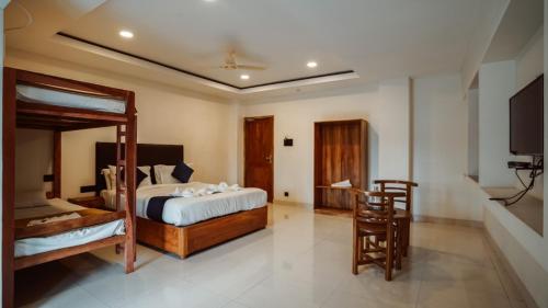 a bedroom with two bunk beds and a flat screen tv at Sayora Hotel in Port Blair