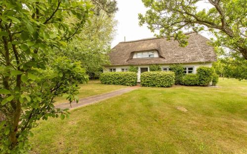 Una casa con un patio con césped en frente. en Luisenhof, en Süderhöft