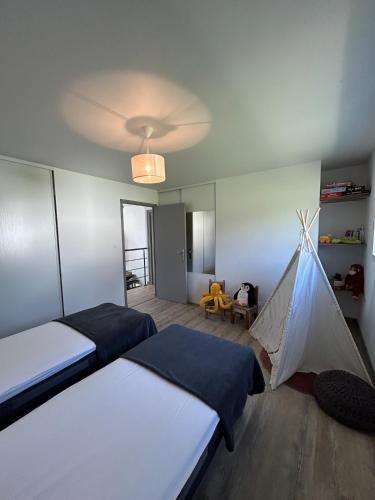 a bedroom with two beds and a tent at Maison de l'écluse in Arzal