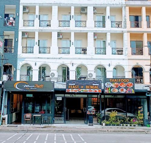 a large white building with a fast food restaurant at Moonlight Inn Hotel Pattaya - Near Walking Street in Pattaya South