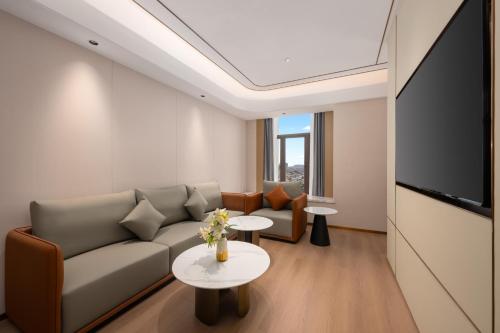 a living room with a couch and a tv at Platon International Apartment - Lunjiao Metro Station Store in Shunde