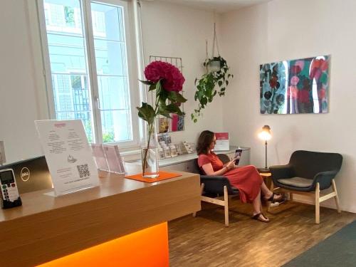 a woman sitting in a chair in a room at Josephine's Guesthouse - ! WOMEN ONLY ! in Zürich