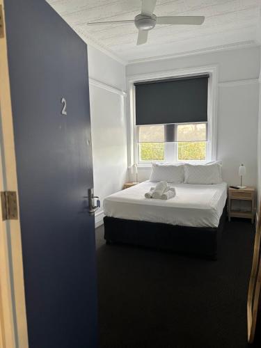 a bedroom with a white bed and a window at The Boatrowers Hotel in Stockton