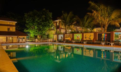a swimming pool at night with chairs around it at Hapuwani Village Lodge in Mulanje