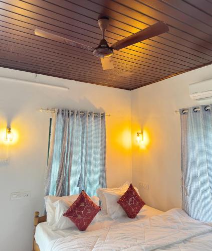 a bedroom with a bed with two pillows and a ceiling at Coconut Bay Marari in Mararikulam