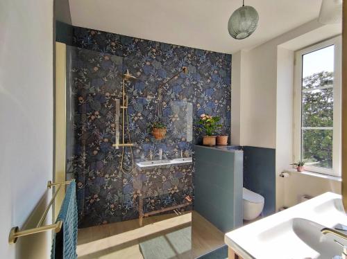 a bathroom with a shower and a sink and a toilet at Ô Bulles de Loire, Châteauneuf-sur-Loire in Châteauneuf-sur-Loire