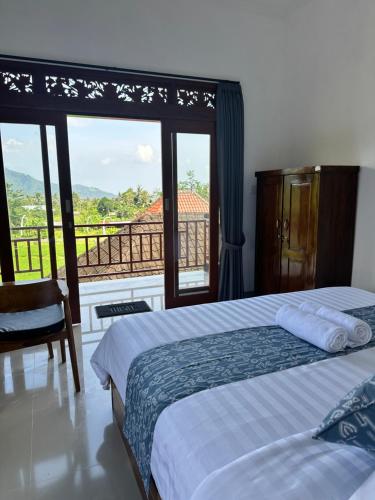 a bedroom with two beds and a window with a view at Merta House Sidemen in Sidemen