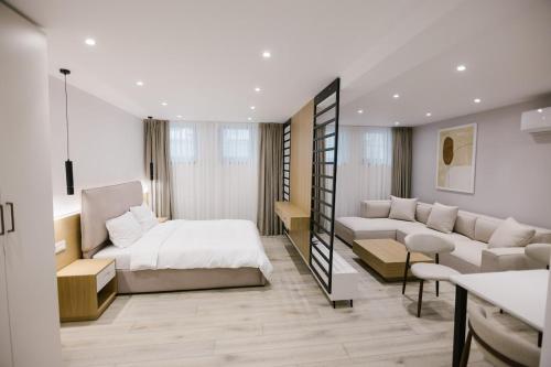 ein Wohnzimmer mit einem Bett und einer Couch in der Unterkunft Vila Alko cozy studio apartment -1B in Korçë