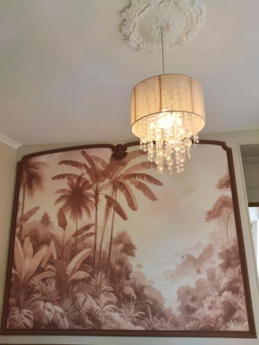 a chandelier and a painting on a wall with a chandelier at Ô Bulles de Loire, Châteauneuf-sur-Loire in Châteauneuf-sur-Loire