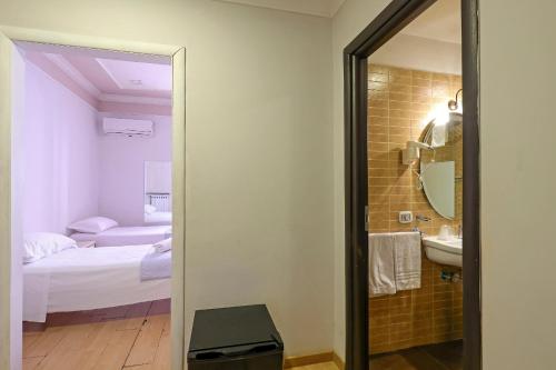 a bathroom with a mirror and a sink and a bed at Hotel Cesare 14 in Naples