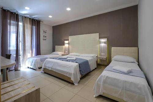 a bedroom with three beds in a room at Hotel Cesare 14 in Naples