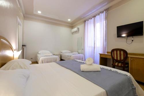 a hotel room with a bed with a towel on it at Hotel Cesare 14 in Naples