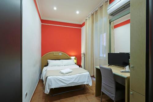 a bedroom with a bed and a desk with a computer at Hotel Cesare 14 in Naples