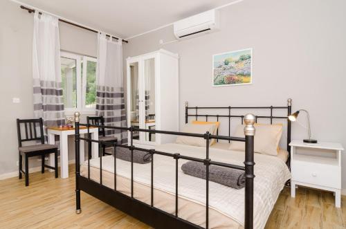 1 dormitorio con 1 cama, 1 mesa y 1 silla en Apartments Porto Della Vita, en Okuklje