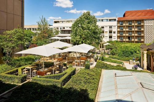 an outdoor garden with white umbrellas in a building at The Westin Grand Berlin in Berlin