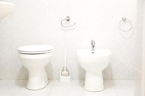 een witte badkamer met een toilet en een bidet bij Corte Cosi&Mia Centro storico in Gallipoli