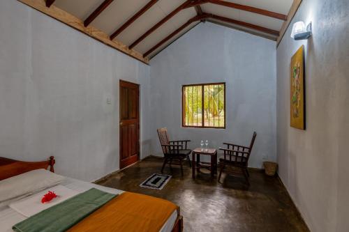 a bedroom with a bed and a table and chairs at WildEscape, Yala Blocks 3 & 5 in Buttala
