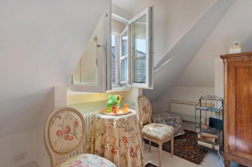 a room with a table and chairs and a window at Attico Palazzo Giustiniani in Genova