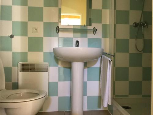 a bathroom with a sink and a toilet at Spacious villa with garden and pool in Les Forges