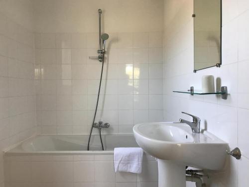 a bathroom with a sink and a bath tub at Spacious villa with garden and pool in Les Forges
