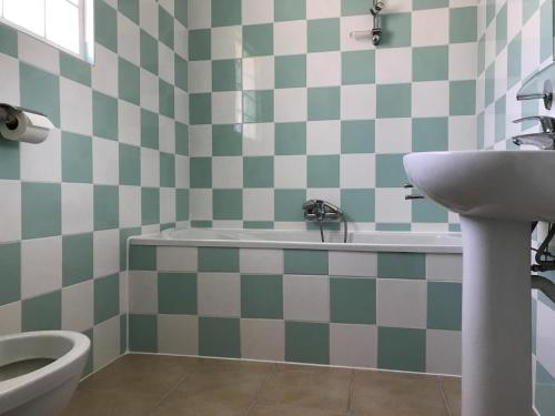 a bathroom with a sink and a tub and a toilet at Spacious villa with garden and pool in Les Forges