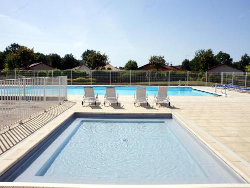 a swimming pool with lounge chairs and a swimming pool at Spacious villa with garden and pool in Les Forges