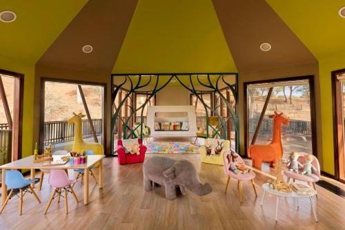 a childrens room with a play area with tables and chairs at The Ritz-Carlton Ras Al Khaimah, Al Wadi Desert in Ras al Khaimah