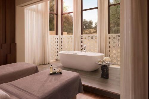 a bathroom with a tub and a large window at The Ritz-Carlton Ras Al Khaimah, Al Wadi Desert in Ras al Khaimah