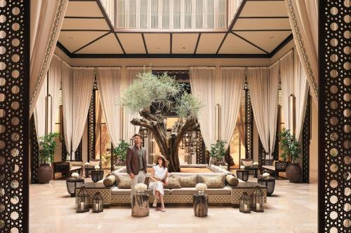 a man and woman sitting on a couch in a lobby at The Ritz-Carlton Ras Al Khaimah, Al Wadi Desert in Ras al Khaimah