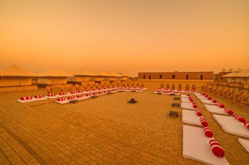 a row of tables and chairs in a courtyard at The Carvaans Resort-Luxury Desert Camp Jaisalmer in Jaisalmer