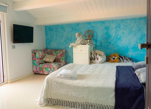 a bedroom with a bed and a blue wall at Morelli's Suite Home in Spoltore