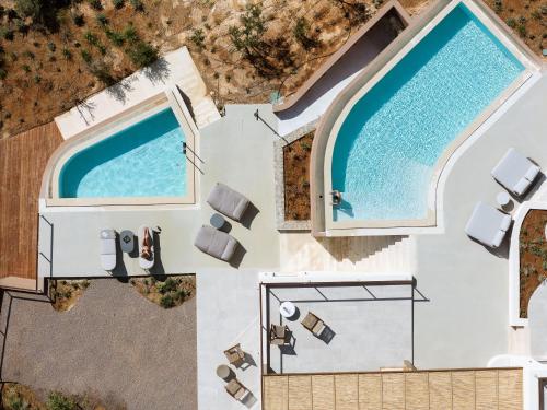 an overhead view of a swimming pool with chairs and a pool at In Blue Villa, Sea View Reverie with a Secluded Beach by etouri in Heraklio Town
