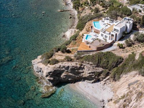 an aerial view of a house on a cliff next to the water at In Blue Villa, Sea View Reverie with a Secluded Beach by etouri in Heraklio Town