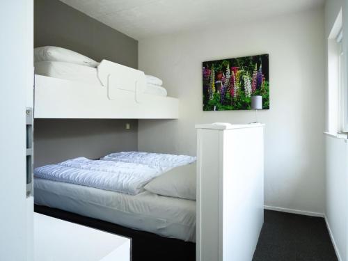 a bedroom with a bunk bed with white sheets at Comfortable family and friends house with wellness in Vlagtwedde