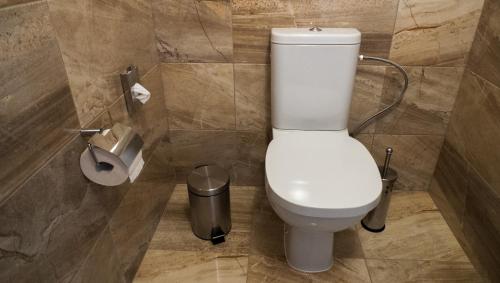 a bathroom with a toilet and a trash can at A7 Apartments in Komárno